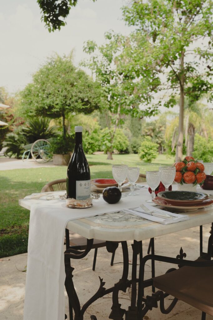 Outdoor dining table set in the garden at Villa Aranjaya in Sicily